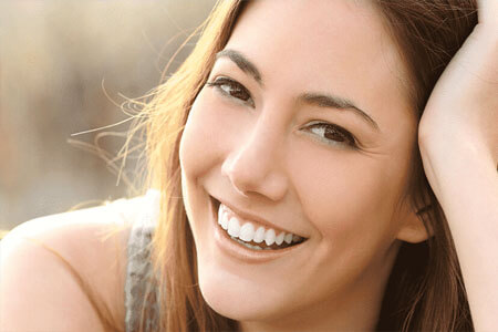 Close-up picture of a brunette woman smiling at the camera