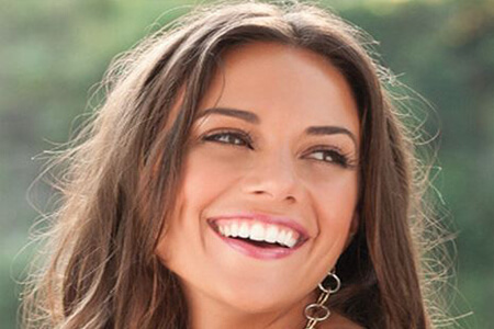 Picture of a brunette young woman smiling back at the camera