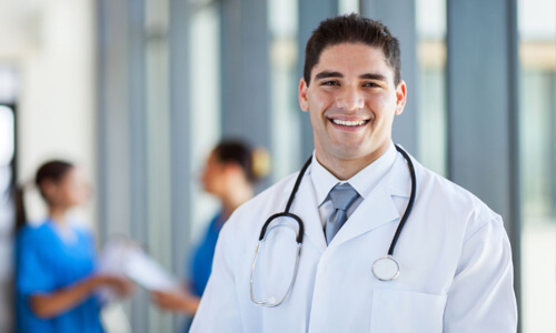 Close-up picture of a young doctor smiling back at the camera