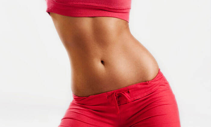 Picture of a woman wearing red pants and showing off her trim abdomen