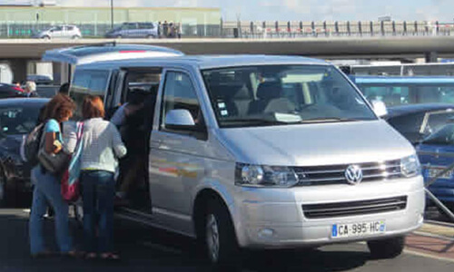 Picture of a gray van picking up passengers