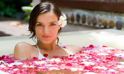 Picture of a young woman taking a flower bath