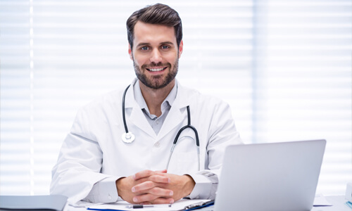 Close-up picture of a young doctor smiling back at the camera